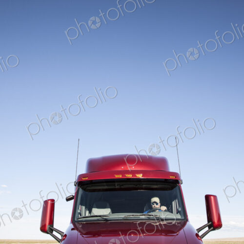 View of a Caucasian woman driver in the cab of her commercial truck. View of a Caucasian woman driver in the cab of her commercial truck.
