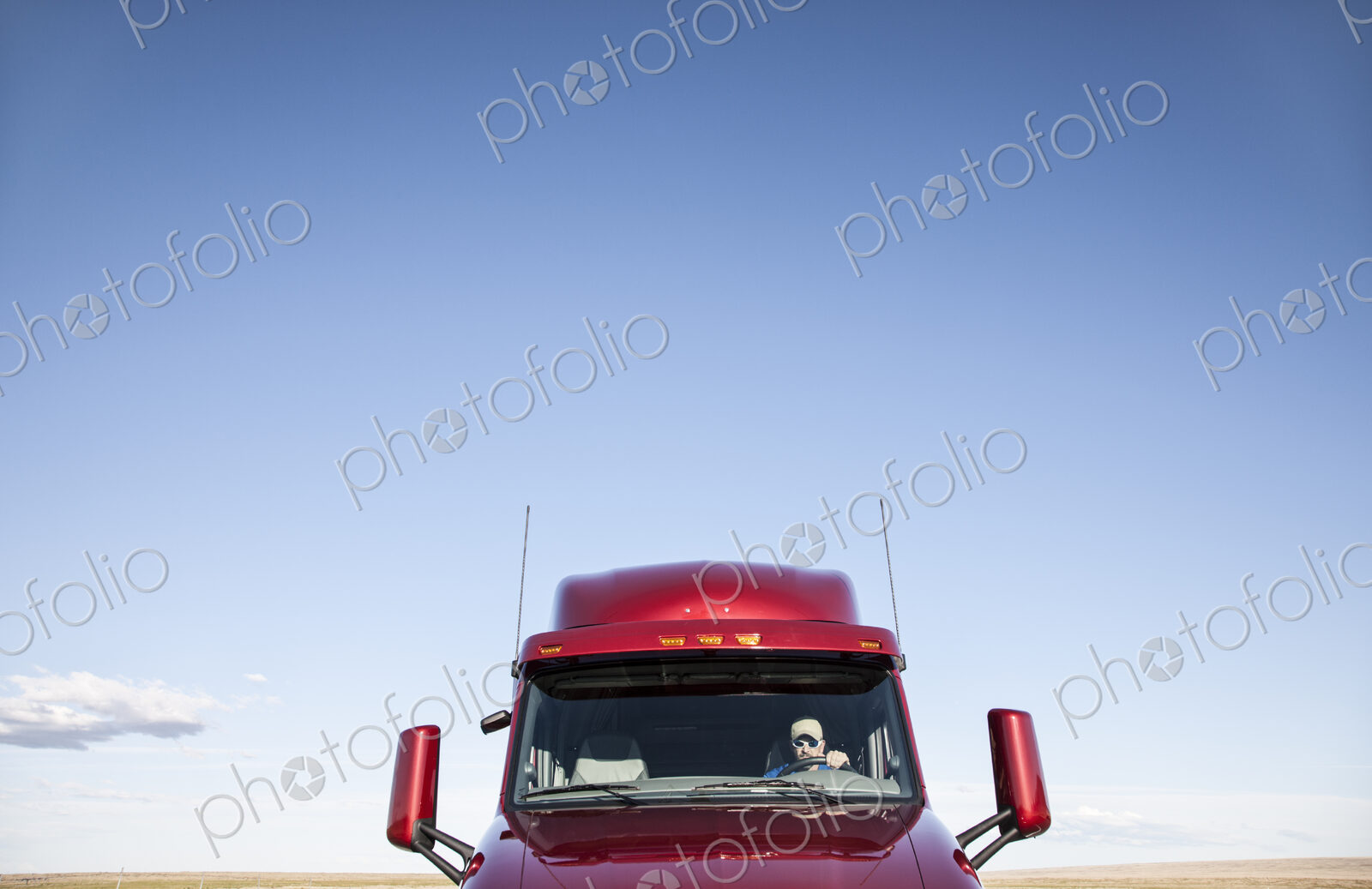 View of a Caucasian woman driver in the cab of her commercial truck.