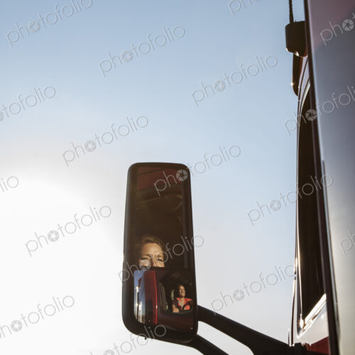 View of a Caucasian woman driver in the cab of her commercial truck. View of a Caucasian woman driver in the cab of her commercial truck.