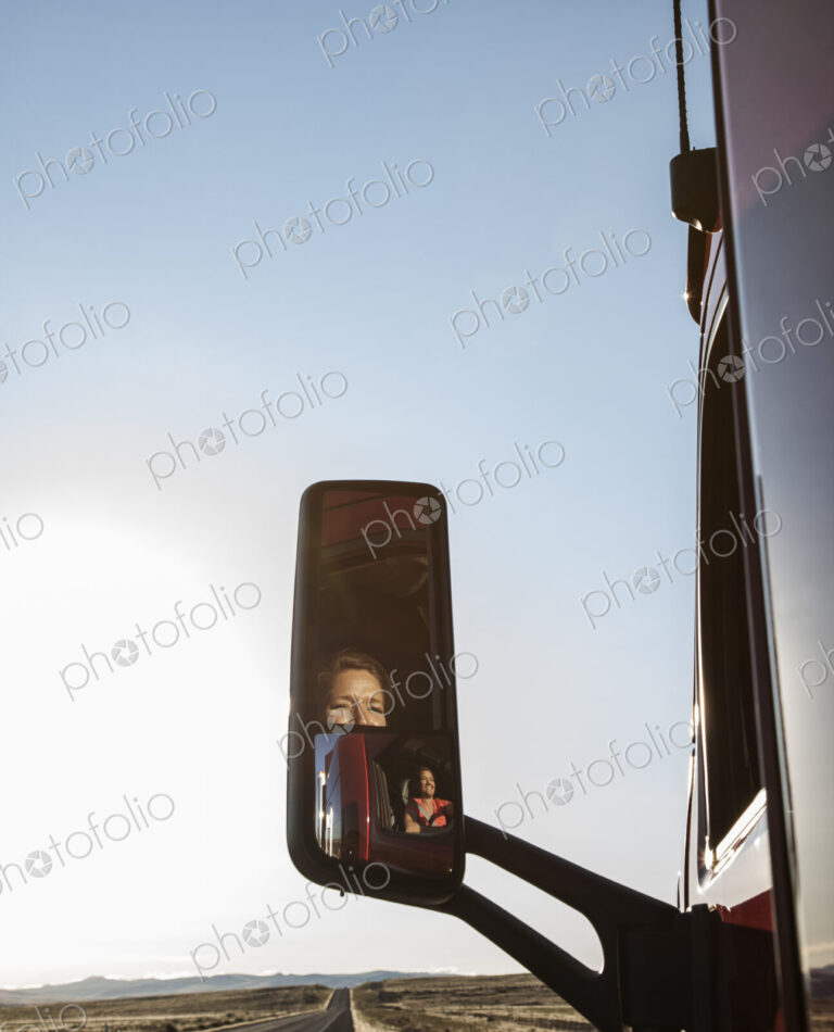 View of a Caucasian woman driver in the cab of her commercial truck.