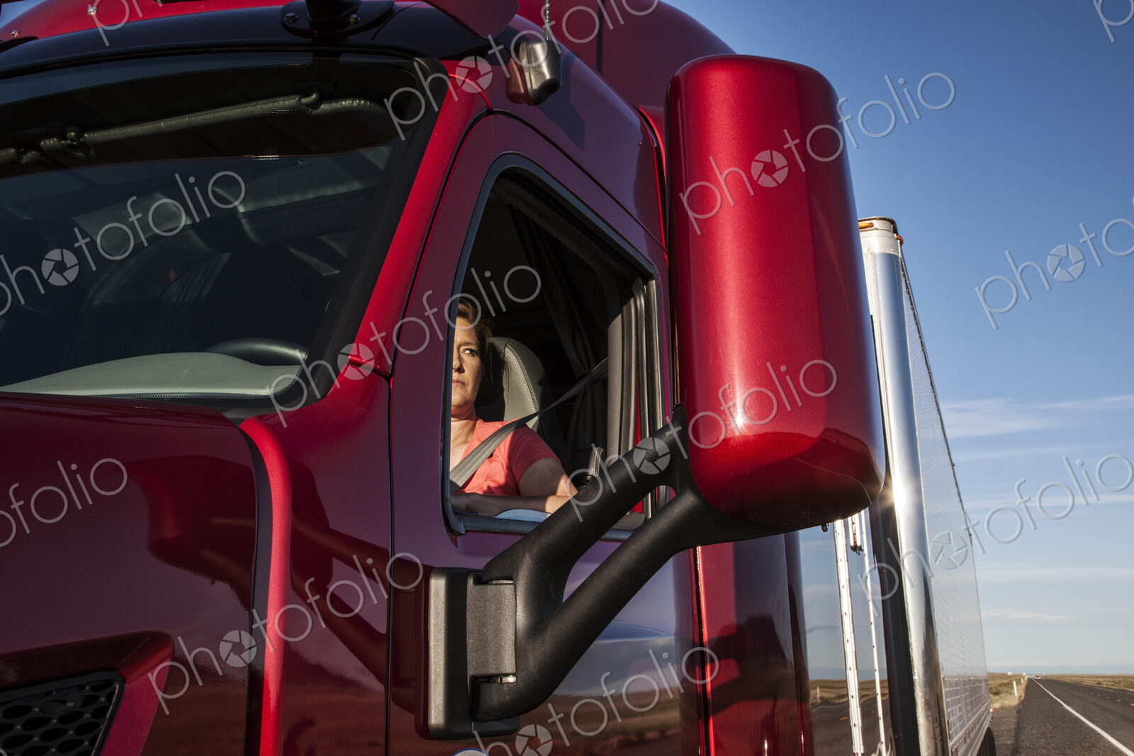 View of a Caucasian woman driver in the cab of her commercial truck.