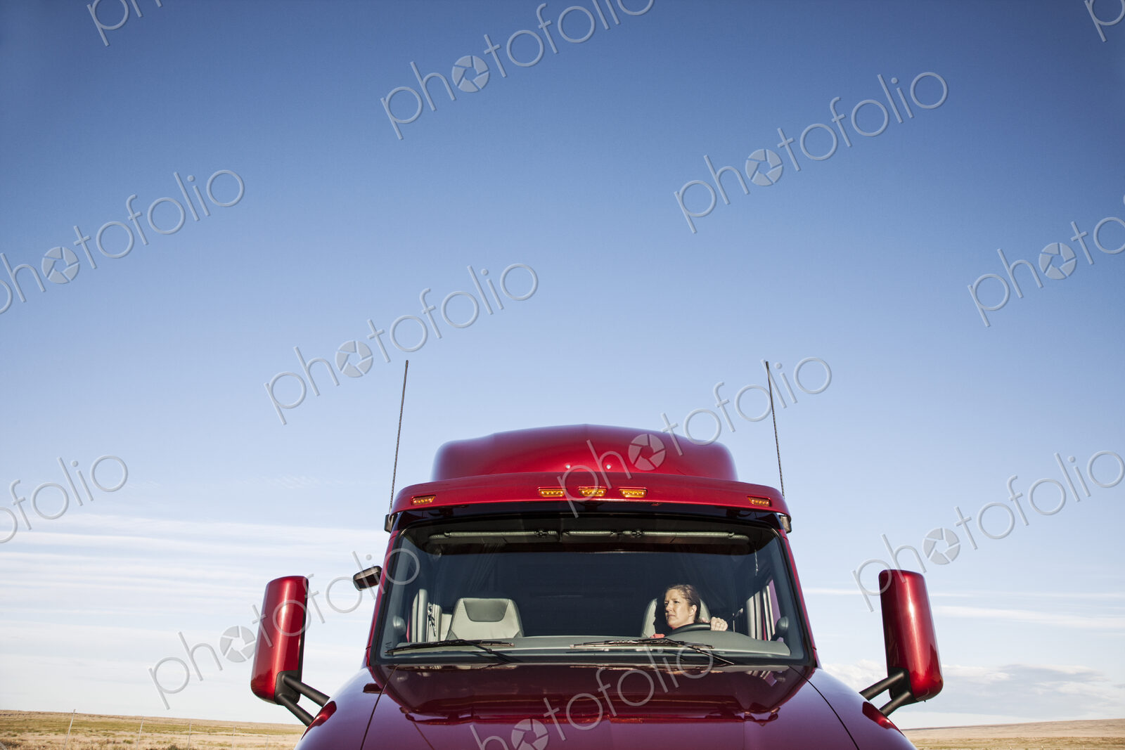 View of a Caucasian woman driver in the cab of her commercial truck.