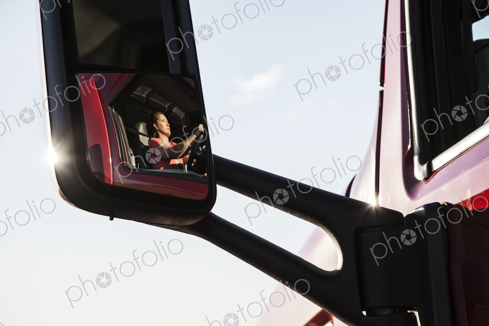 View of a Caucasian woman driver in the cab of her commercial truck.