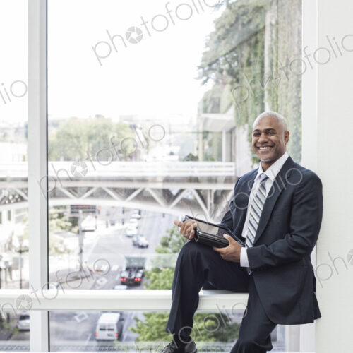 View of a black business man in a dress shirt, tie and suit coat