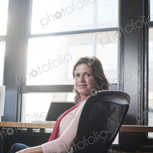 View of a caucasian woman at her desk in a creative office. View of a caucasian woman at her desk in a creative office.