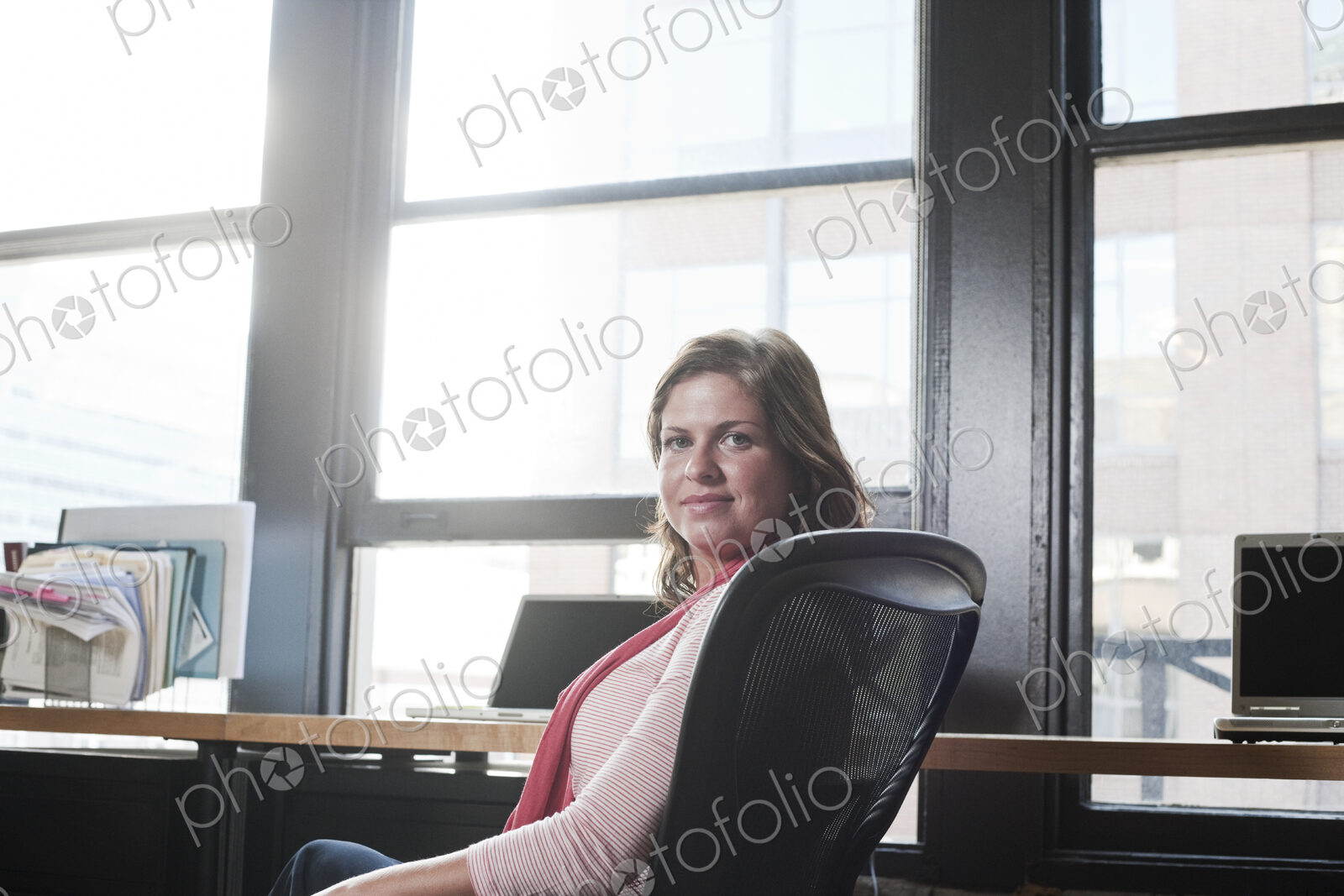 View of a caucasian woman at her desk in a creative office.