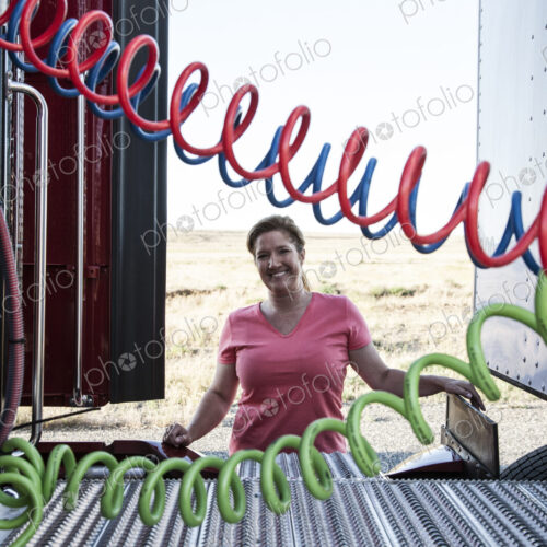 View of a driver connecting the power cords to trailer of a commercial truck.