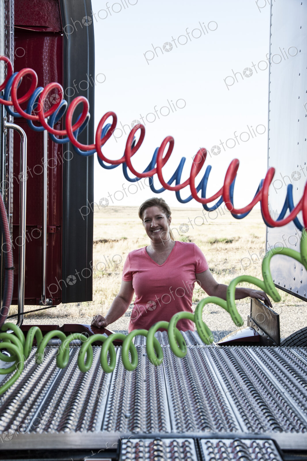 View of a driver connecting the power cords to trailer of a commercial truck.