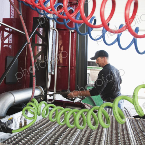 View of a driver putting gas in a commercial truck. View of a driver putting gas in a commercial truck.