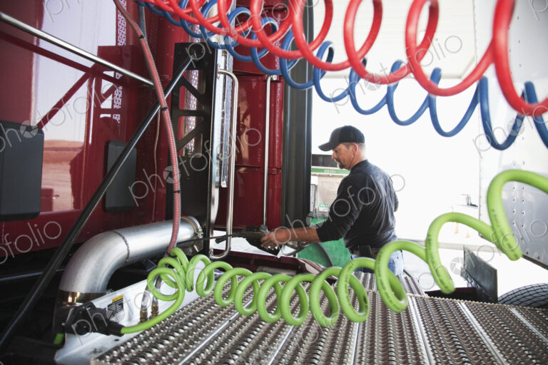View of a driver putting gas in a commercial truck.