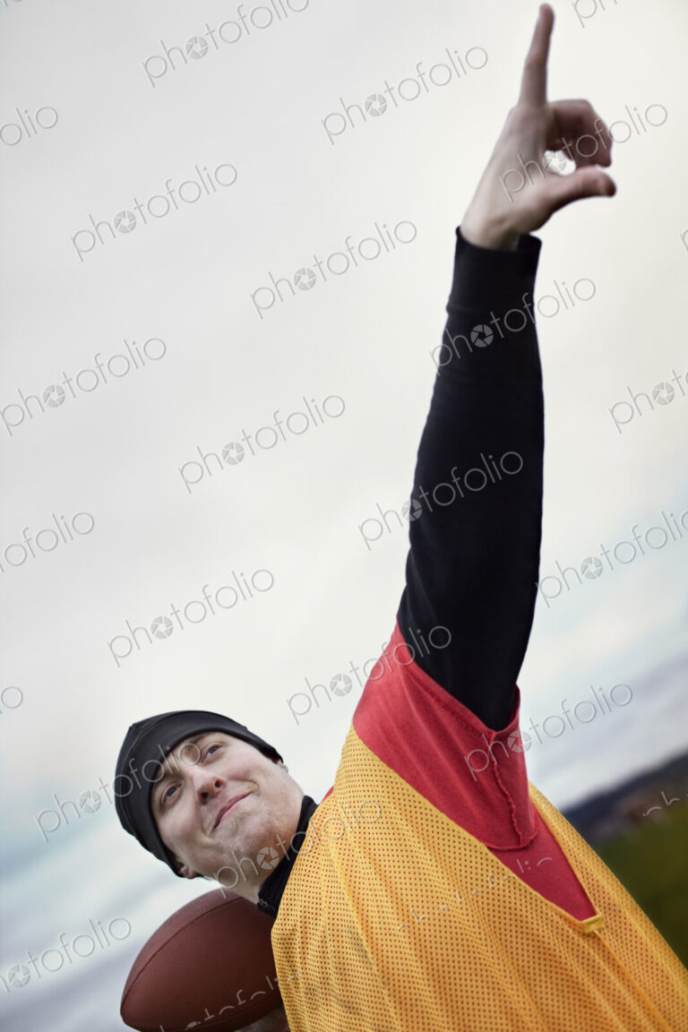 View of a quarterback leaning back and preparing to throw a football.