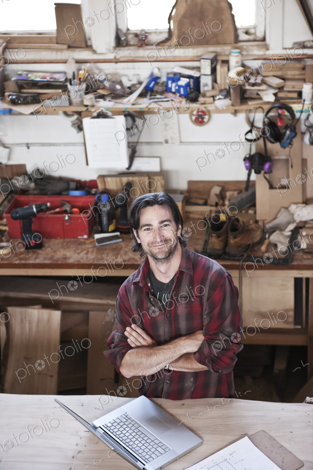 View of a smiling caucasian man factory worker at his work station in a woodworking…