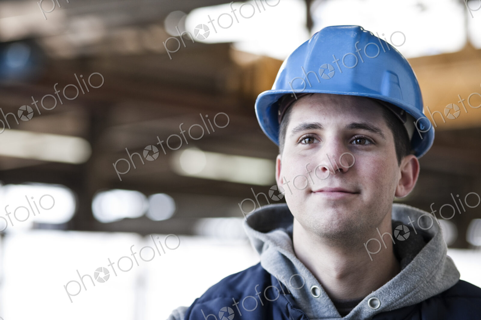 View of a young caucasian factory worker wearing a hard hat in a factory.