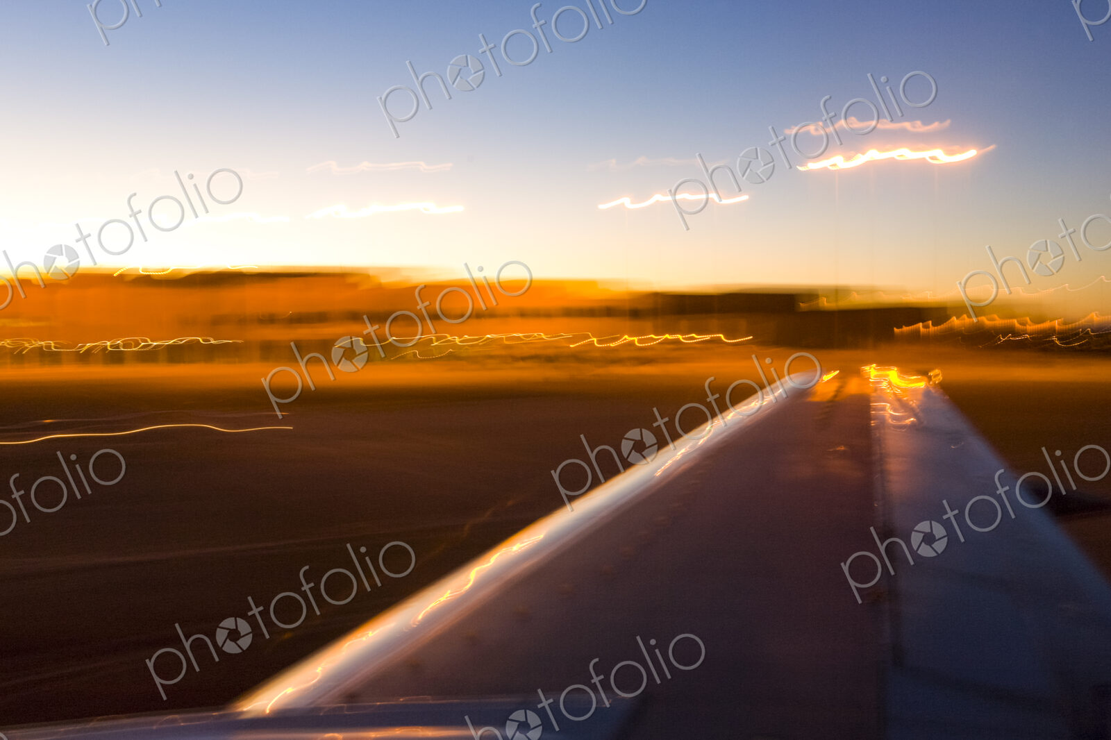View of plane wing while landing at sunset in Nevada.