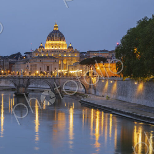 View of the Basilica of St Peter's at dusk across the Tiber River, panoramic view. View of the Basilica of St Peter's at dusk across the Tiber River, panoramic view.