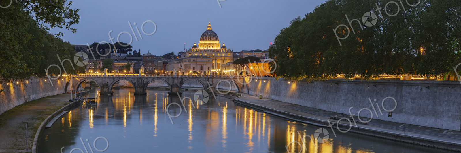 View of the Basilica of St Peter’s at dusk across the Tiber River, panoramic view.