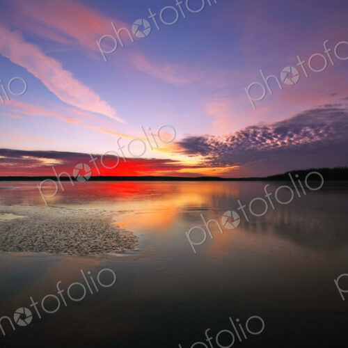 View of the sky and cloud patterns reflected in the frozen surface of a lake. View of the sky and cloud patterns reflected in the frozen surface of a lake.