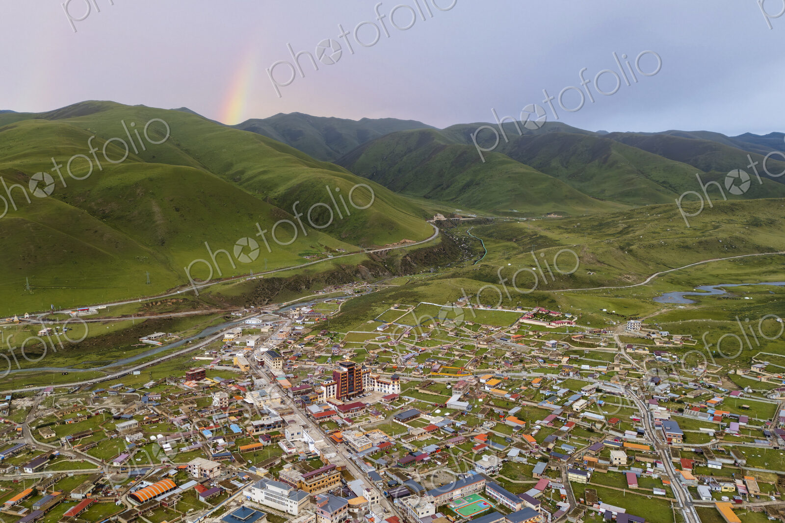 View over Zhuqing at Sunset, a colourful rainbow above the mountains.