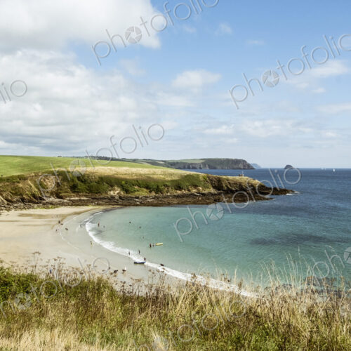 View over a sandy beach and cliffs in summer, a few people, clear shallow water and… View over a sandy beach and cliffs in summer, a few people, clear shallow water and…