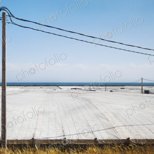 View over plastic greenhouses and crop cover, over a large area by the coast,… View over plastic greenhouses and crop cover, over a large area by the coast,…