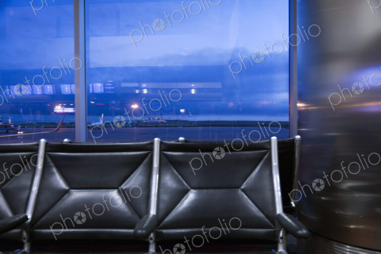 View through an airport window of buildings, of the traffic on the airport runways and…