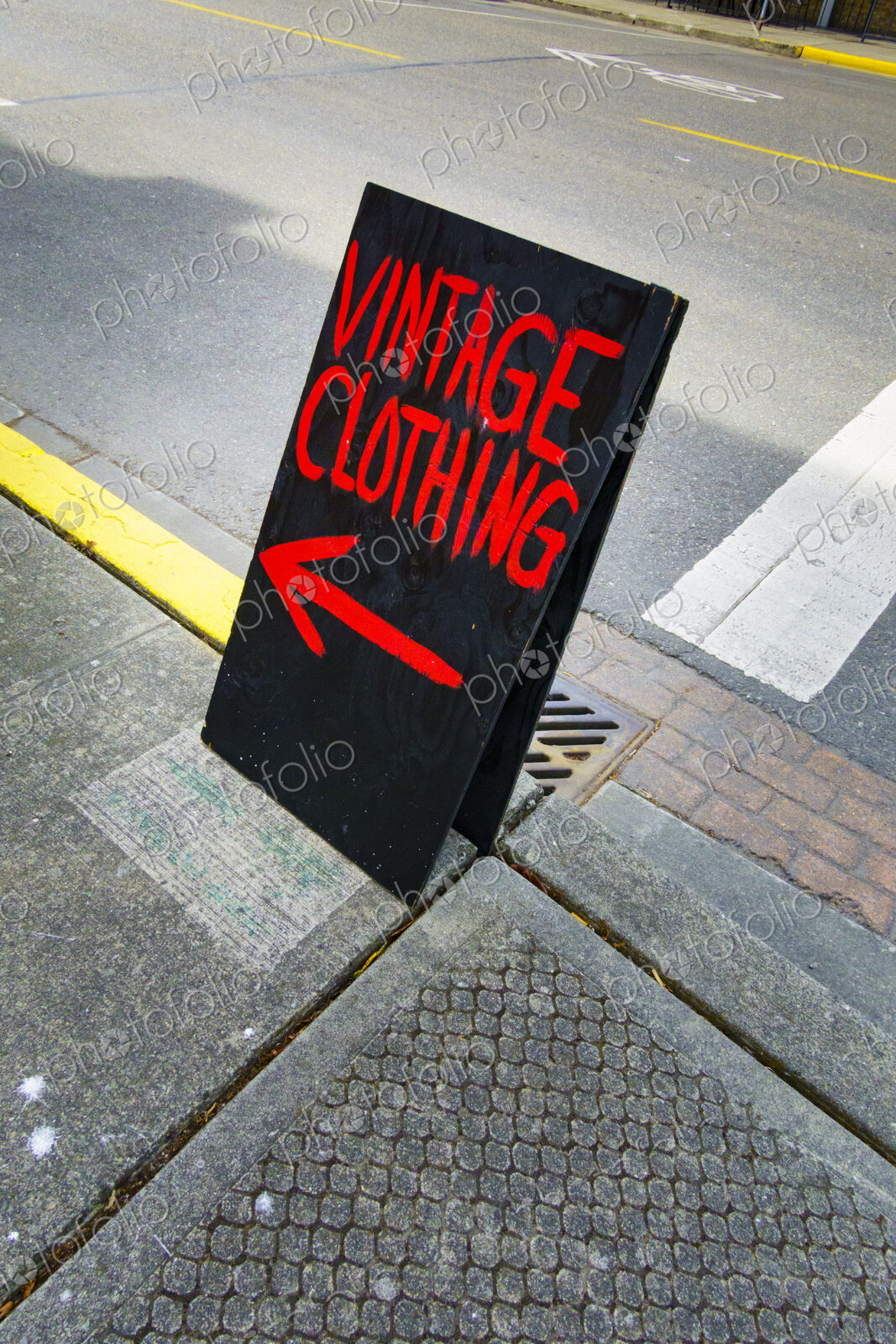 Vintage clothing shop A board sign, a chalk board on a sidewalk with red writing and a…