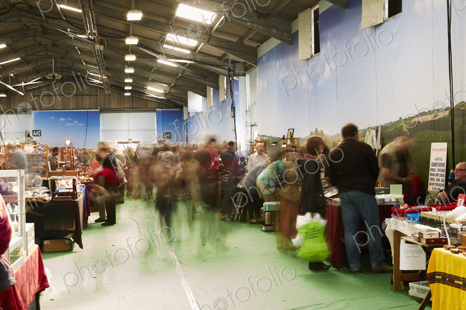 Visitors browsing items at stalls at a busy flea market.