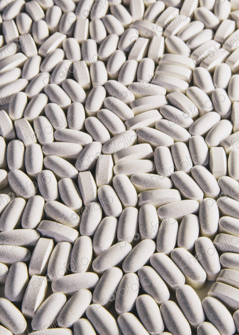 Vitamin C supplements, white oval tablets for consumption.