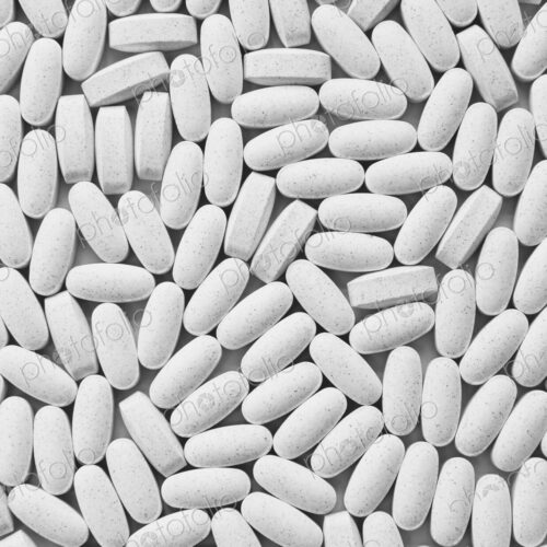 Vitamin C supplements, white oval tablets, taken for health reasons.