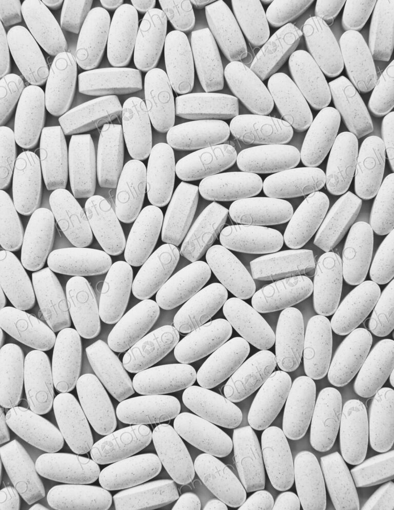 Vitamin C supplements, white oval tablets, taken for health reasons.