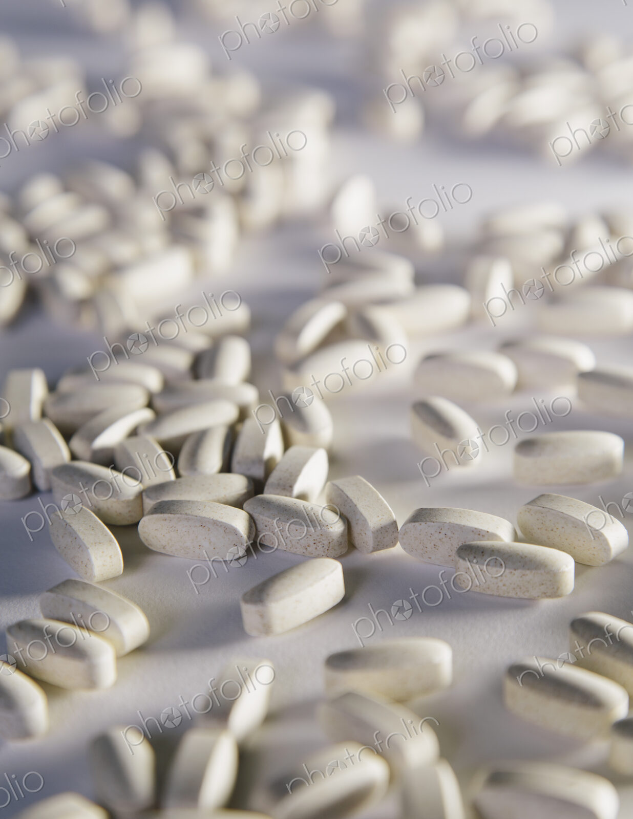 Vitamin C supplements, white oval tablets taken for health reasons. Spread out on a…