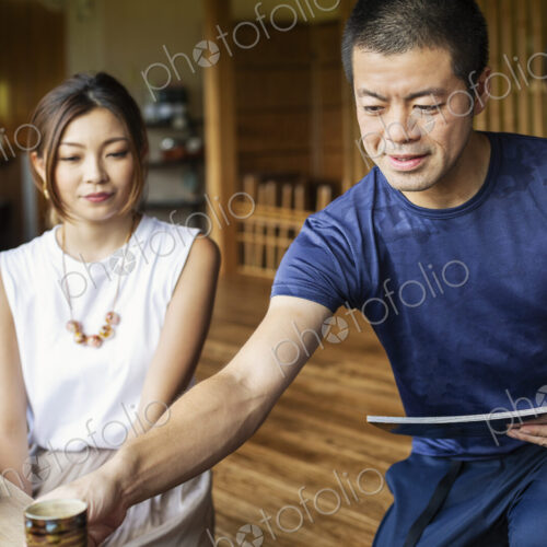 Waiter serving two Japanese women sitting at a table in a Japanese restaurant. Waiter serving two Japanese women sitting at a table in a Japanese restaurant.