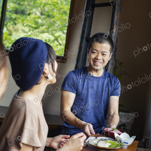 Waiter serving two Japanese women sitting at a table in a Japanese restaurant. Waiter serving two Japanese women sitting at a table in a Japanese restaurant.