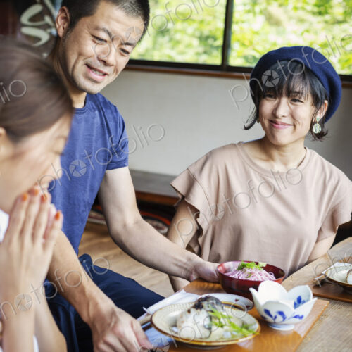 Waiter serving two Japanese women sitting at a table in a Japanese restaurant. Waiter serving two Japanese women sitting at a table in a Japanese restaurant.