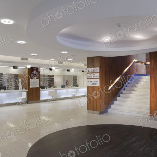 Waiting area and reception desk at a modern hospital, with signs and electronic display Waiting area and reception desk at a modern hospital, with signs and electronic display
