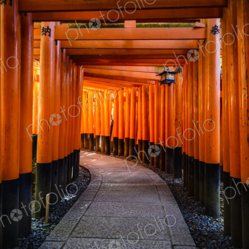Walkway under orange wooden pillars