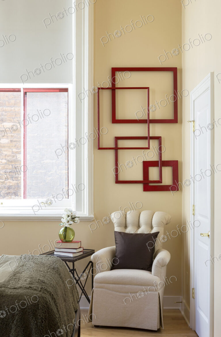 Wall art and armchair in corner of bedroom