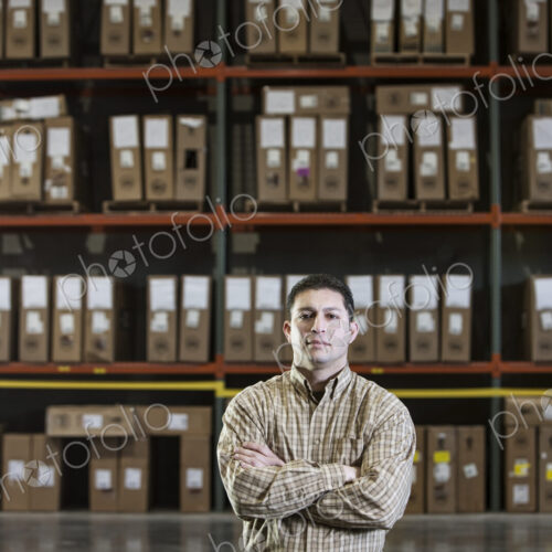 Warehouse worker by a rack of stock in a distribution warehouse. Warehouse worker by a rack of stock in a distribution warehouse.