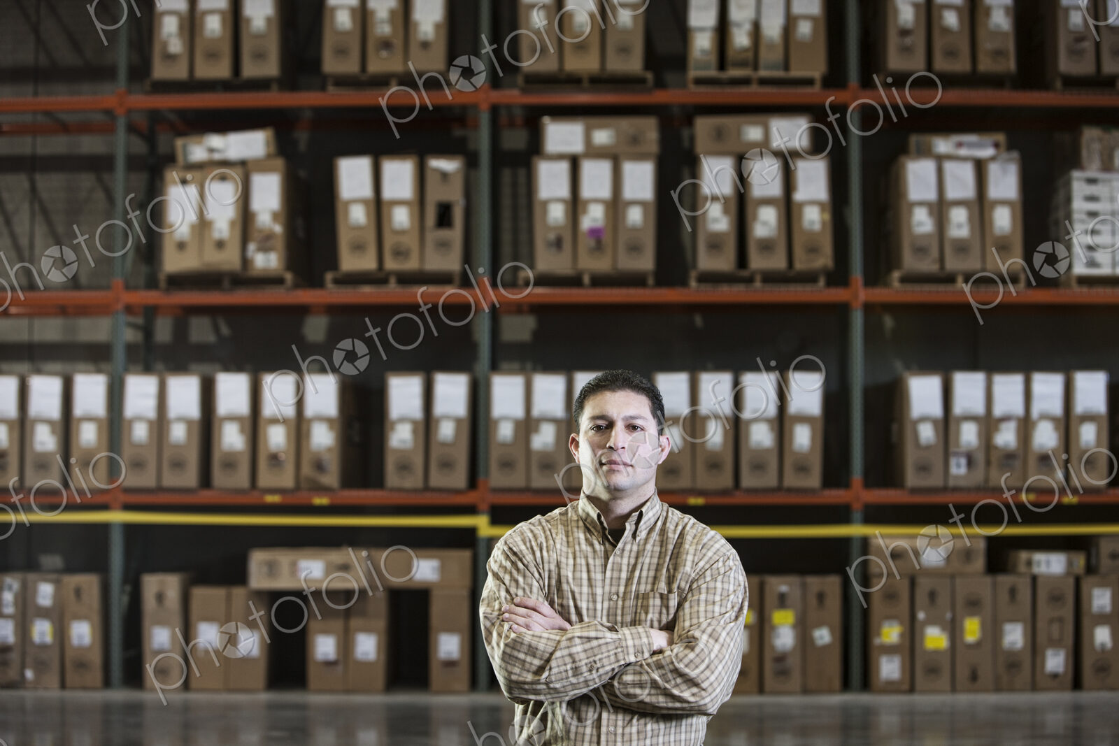 Warehouse worker by a rack of stock in a distribution warehouse.