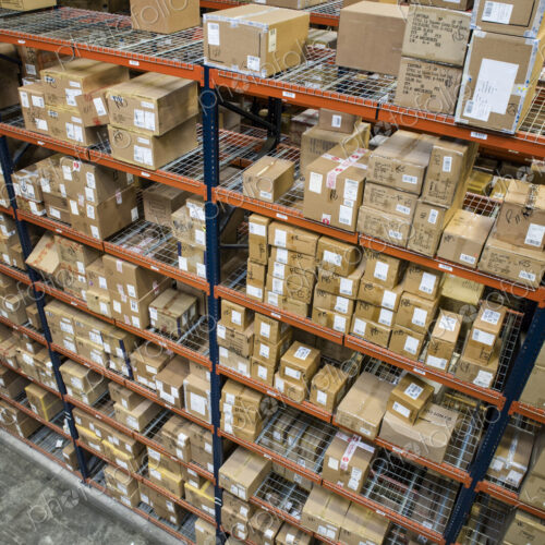 Warehouse worker checking inventory of boxes on racks in a distribution warehouse. Warehouse worker checking inventory of boxes on racks in a distribution warehouse.
