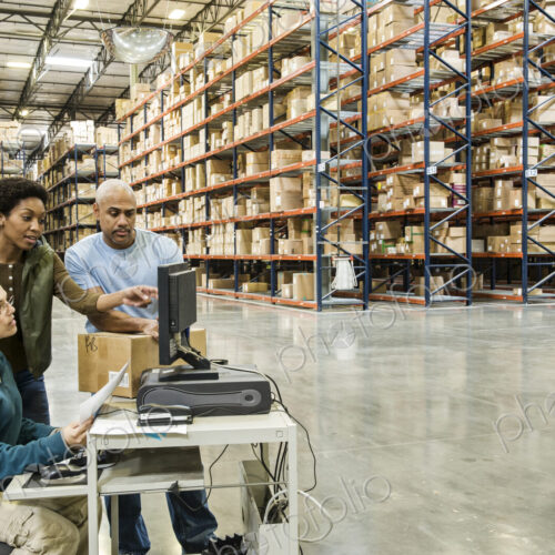 Warehouse workers checking inventory on a computer in a large distrubiton warehouse. Warehouse workers checking inventory on a computer in a large distrubiton warehouse.