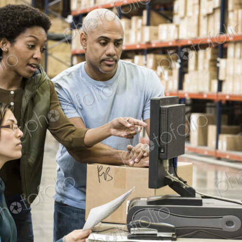 Warehouse workers checking inventory on a computer in a large distrubiton warehouse. Warehouse workers checking inventory on a computer in a large distrubiton warehouse.