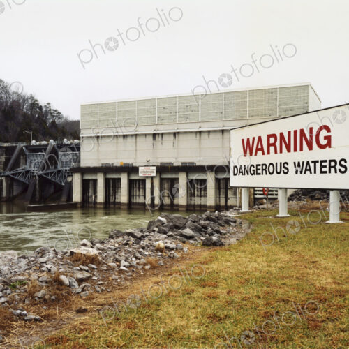 Warning signs by a water channel, Dangerous Waters. A covered bridge, water flow…