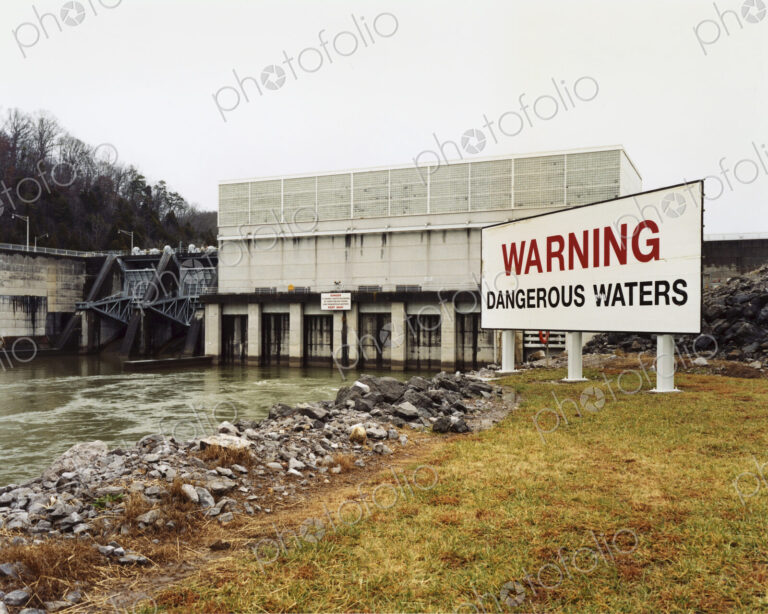Warning signs by a water channel, Dangerous Waters. A covered bridge, water flow…