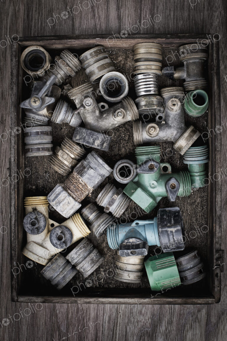 Washers and hose pipe joint fittings in a wooden box in the greenhouse.
