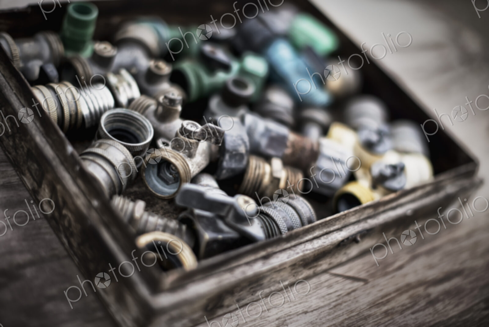 Washers and hose pipe joint fittings in a wooden box in the greenhouse.