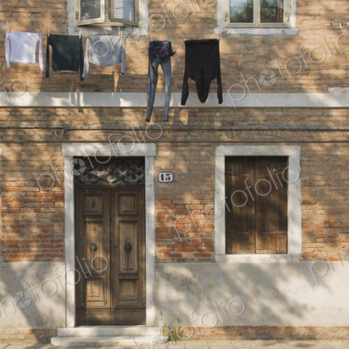 Washing line with laundry hanging on brick building exterior.