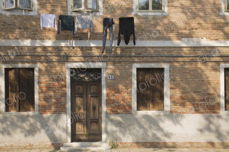 Washing line with laundry hanging on brick building exterior.