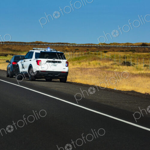 Washington State Trooper vehicle with lights on pulling over a vehicle to the roadside.