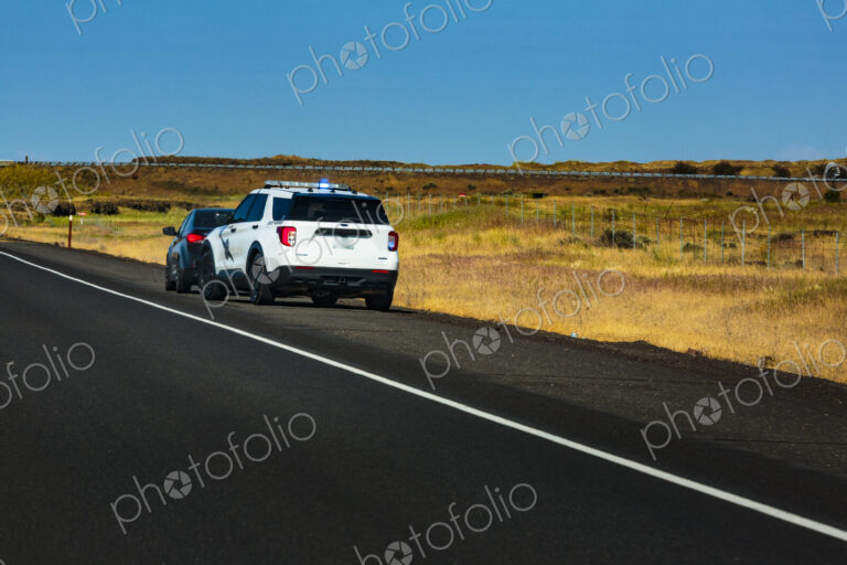 Washington State Trooper vehicle with lights on pulling over a vehicle to the roadside.